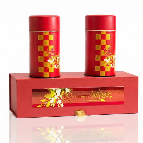 Two red tea canisters with gold patterns on a matching red box.